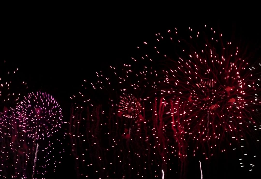 Rotes Feuerwerk mit Herzen am Nachthimmel